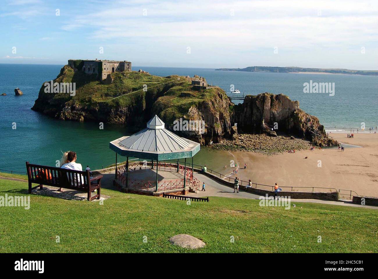Coppia seduta che guarda al Fort and Island di St Catherine, Tenby, Pembrokeshire, Galles, Gran Bretagna Foto Stock