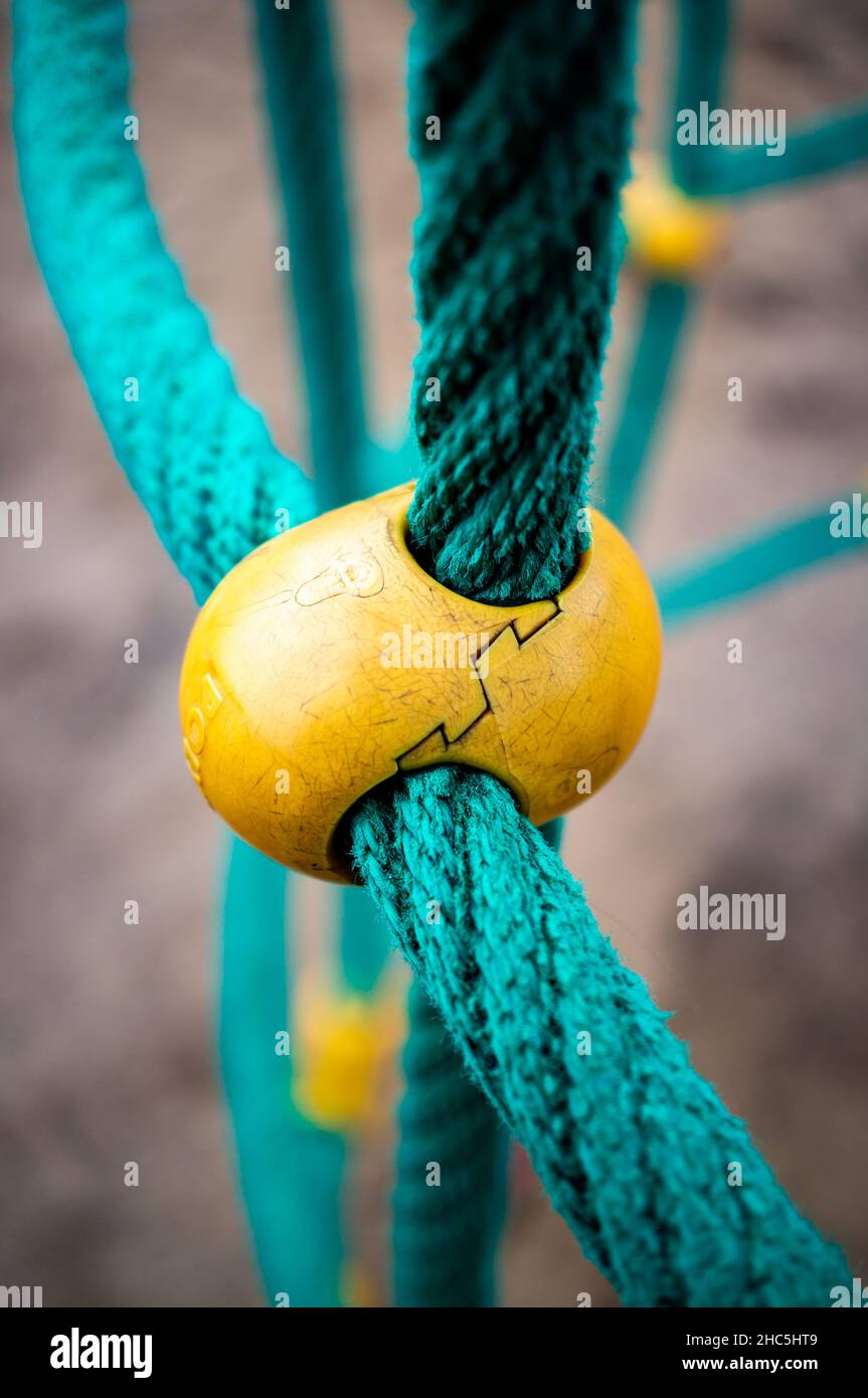 Closeup verticale di funi spesse collegate con un morsetto in plastica Foto Stock