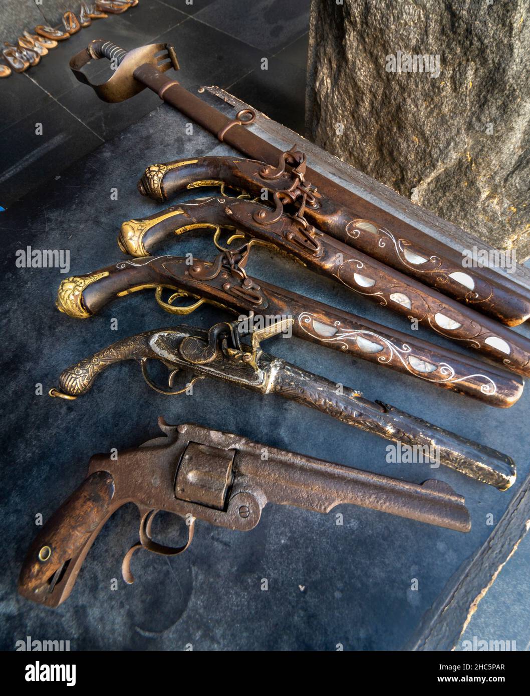 Arrugginite vecchie armi, tra cui un revolver, pistole a polvere e spada disposte per la vendita ai turisti, a causa della più alta connessione militare al servizio di guerra Foto Stock