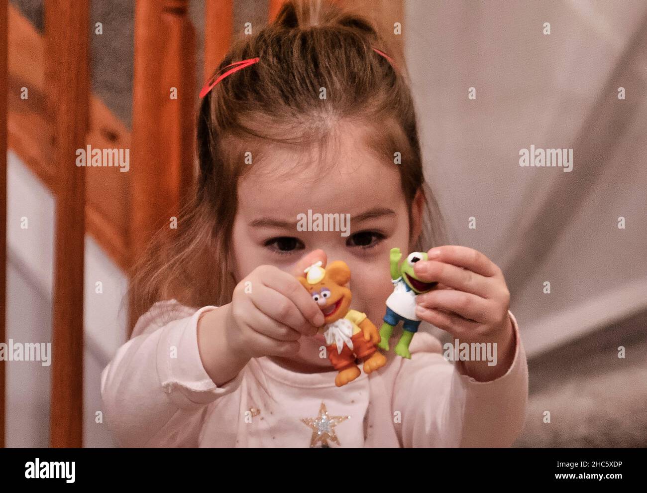 Giovane ragazza felice di mostrare i suoi nuovi giocattoli Foto Stock