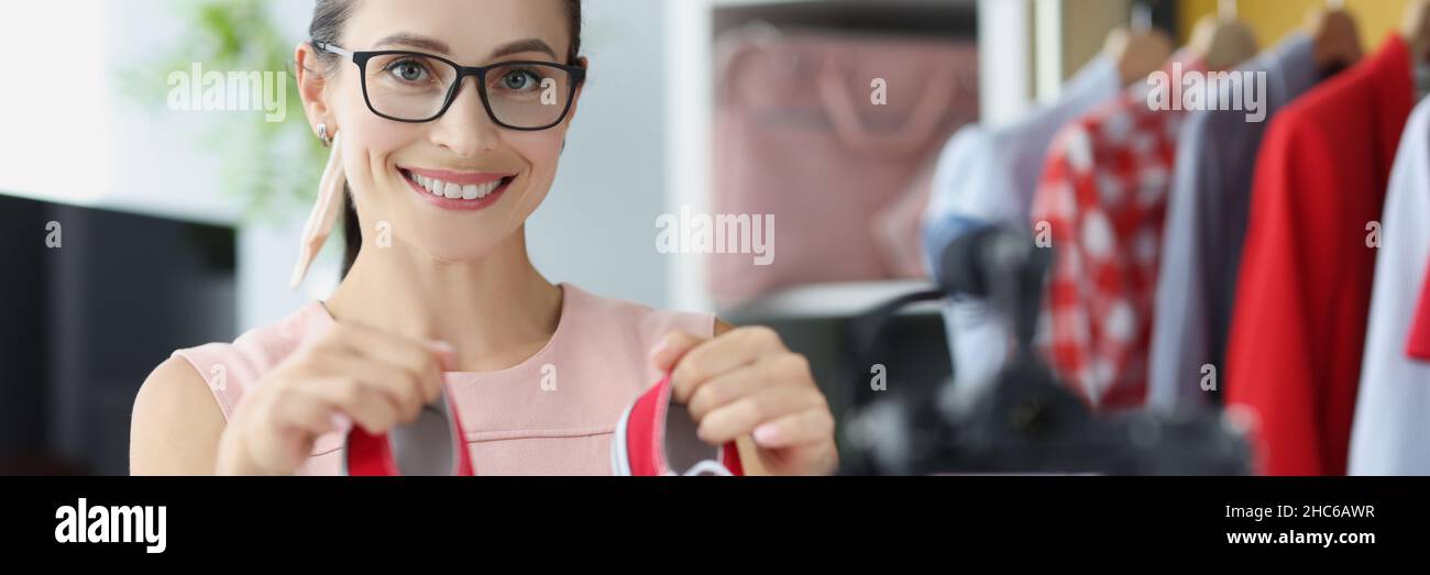 Donna blogger consiglia di acquistare scarpe rosse sport in negozio online primo piano Foto Stock