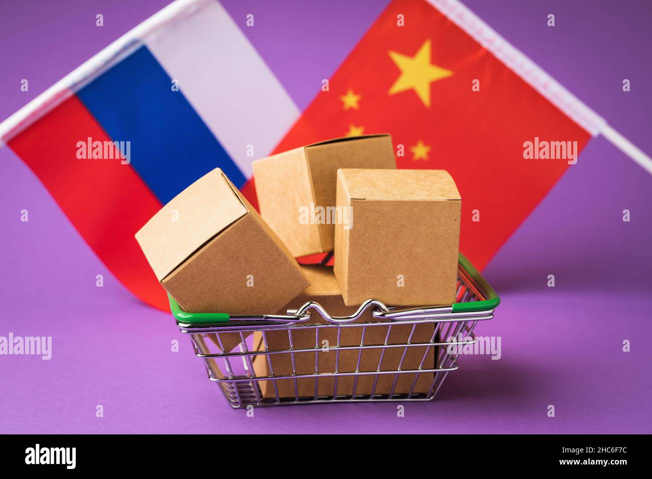 Scatole in un cestino di cibo, bandiere di Russia e Cina su uno sfondo colorato, il concetto di commercio tra Russia e Cina Foto Stock