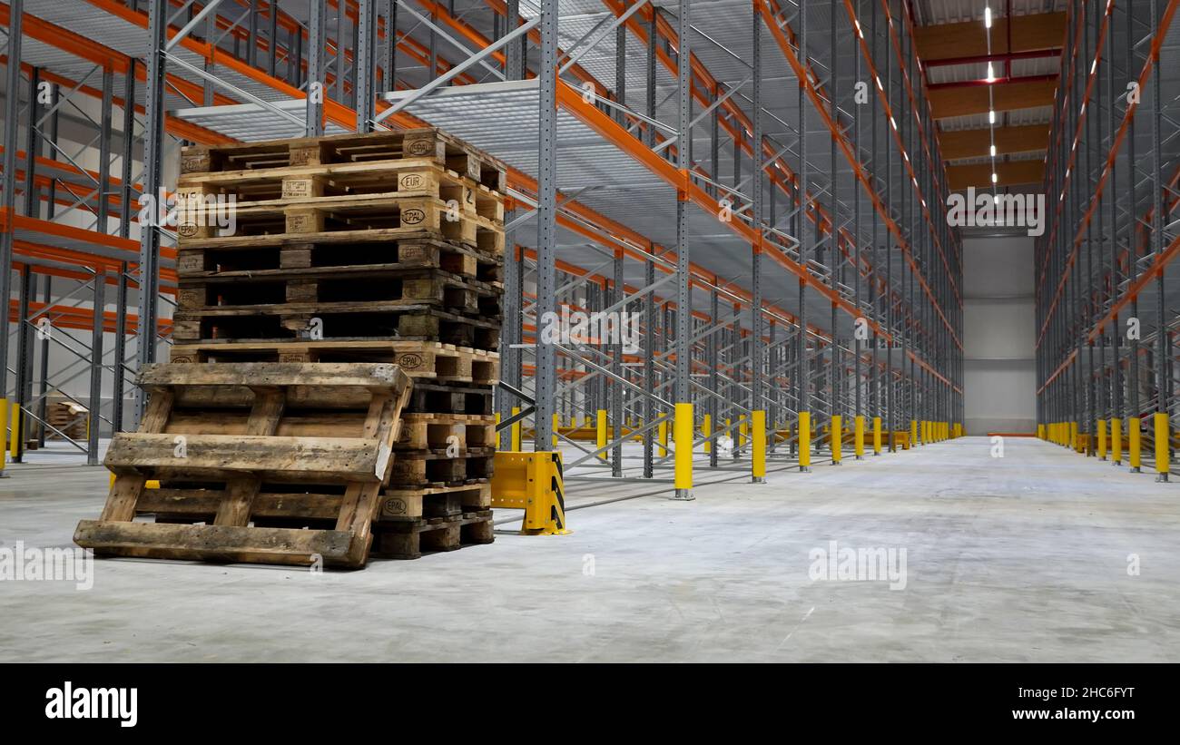 Pallet impilati vuoti nel magazzino logistico Foto Stock