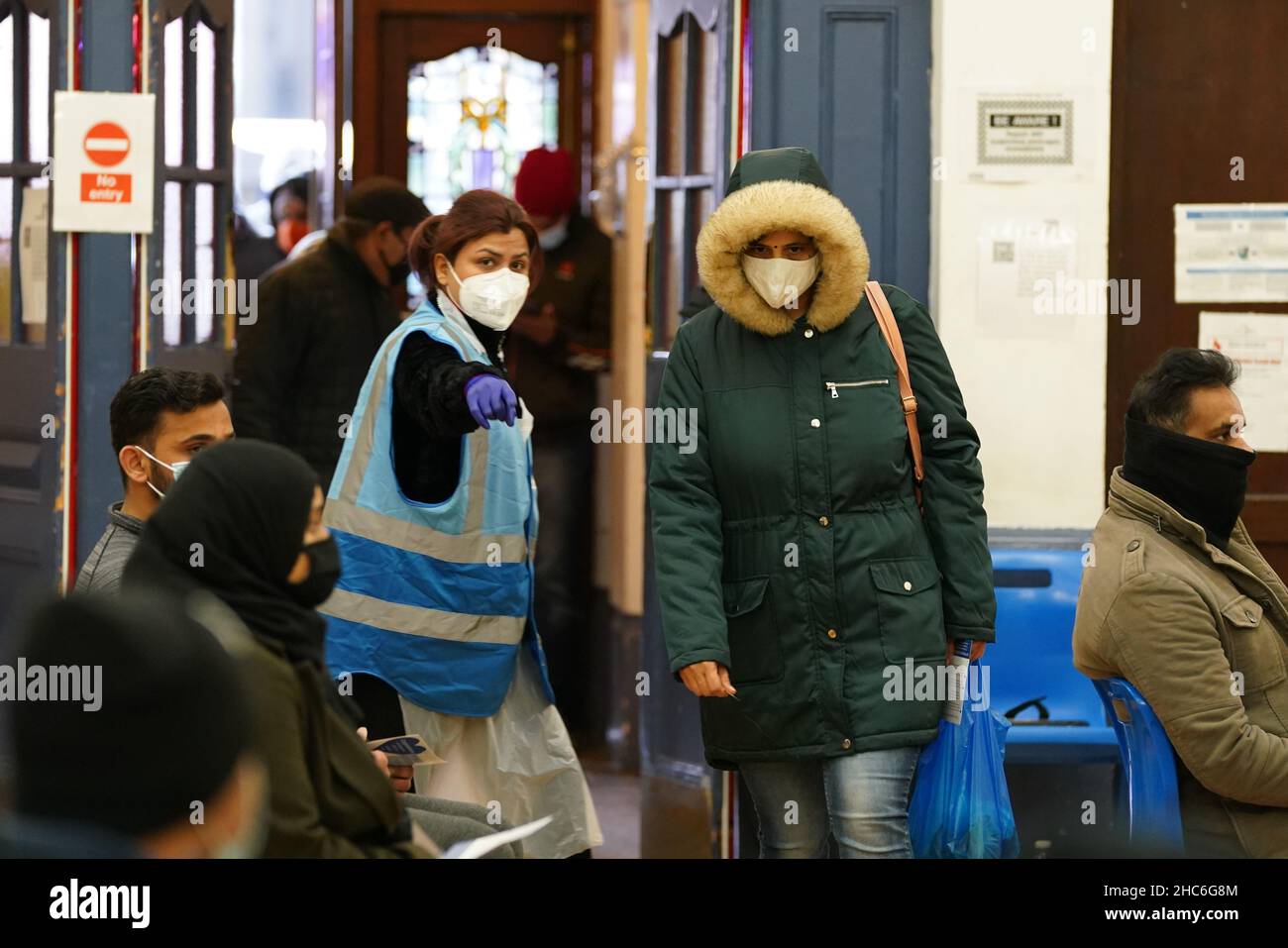 La gente arriva a ricevere un'iniezione di richiamo della vaccinazione 'Jingle Jab' di Covid al Municipio di Redbridge, ad Ilford, Essex, mentre il programma di richiamo del coronavirus continua in tutto il Regno Unito il giorno di Natale. Data foto: Sabato 25 dicembre 2021. Foto Stock