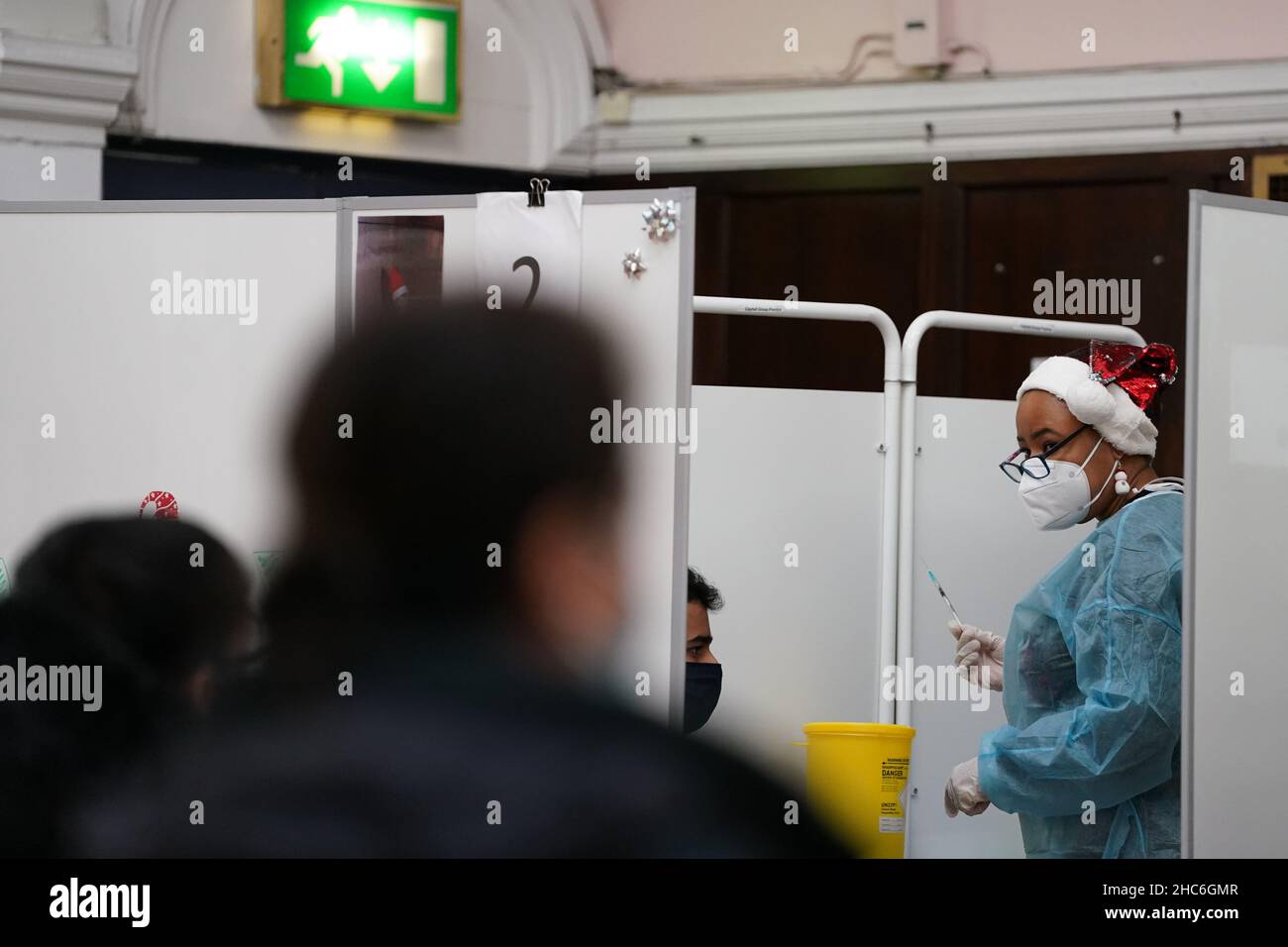 Un vaccinatore prepara un'iniezione di richiamo della vaccinazione 'Jingle Jab' di Covid al Municipio di Redbridge, ad Ilford, Essex, mentre il programma di richiamo del coronavirus continua in tutto il Regno Unito il giorno di Natale. Data foto: Sabato 25 dicembre 2021. Foto Stock