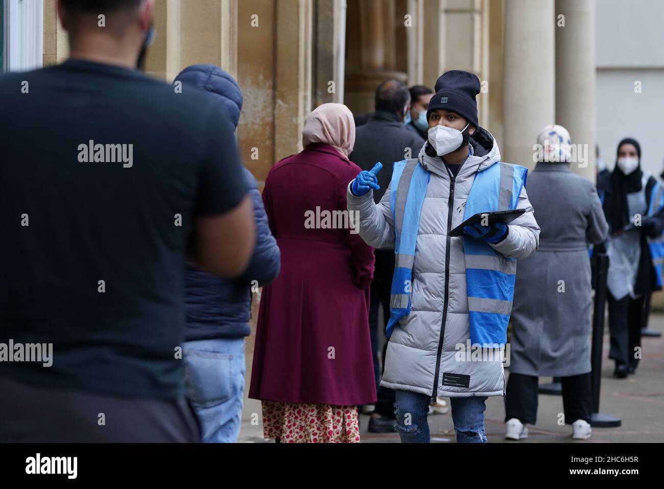 La gente arriva a ricevere un'iniezione di richiamo della vaccinazione 'Jingle Jab' di Covid al Municipio di Redbridge, ad Ilford, Essex, mentre il programma di richiamo del coronavirus continua in tutto il Regno Unito il giorno di Natale. Data foto: Sabato 25 dicembre 2021. Foto Stock