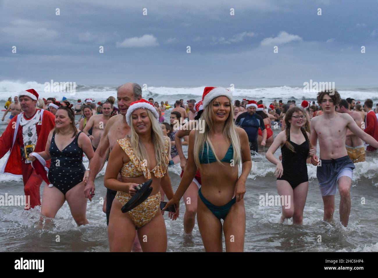 Bude, Cornovaglia, Regno Unito. 25th dicembre 2021. Il Natale nuota. Centinaia di persone si sono rivolte per un tuffo festoso in mare a Bude questa mattina. Credit Simon Maycock / Alamy Live News. Foto Stock