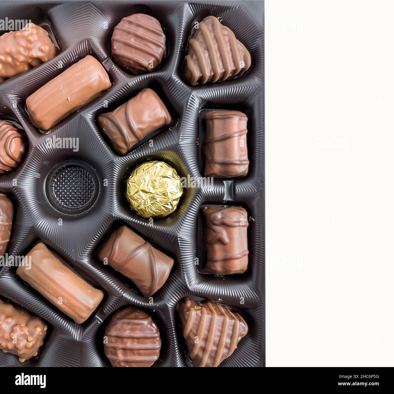 Cioccolatini in una scatola. Disposizione piatta . Raccolta di cioccolatini nella scatola con uno mancante. Spazio per scrivere. Immagine stock. Foto Stock