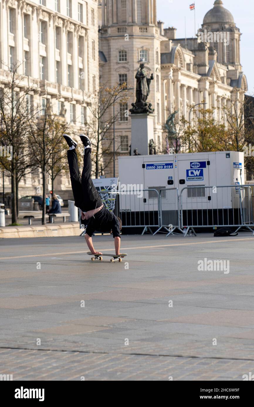 Skateboarder esecuzione di trucchi sulla strada a Liverpool City Foto Stock