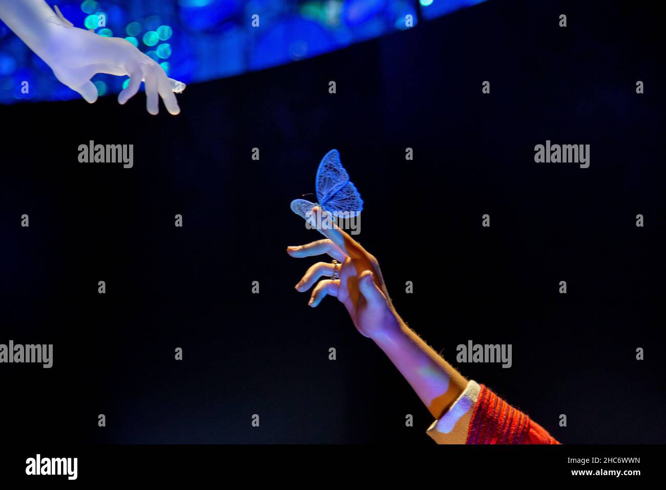 Ragazza che raggiunge il contatto con una ragazza di vetro dalle farfalle nel Padiglione Alif dell'Expo 2020 Foto Stock