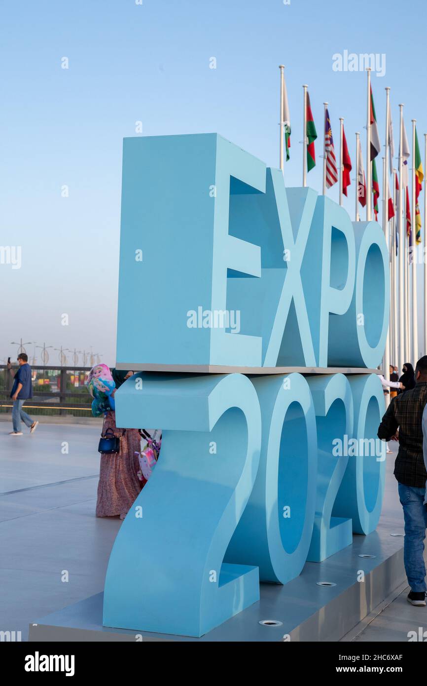 Persone che camminano di fronte a un cartello blu Expo 2020 Foto Stock