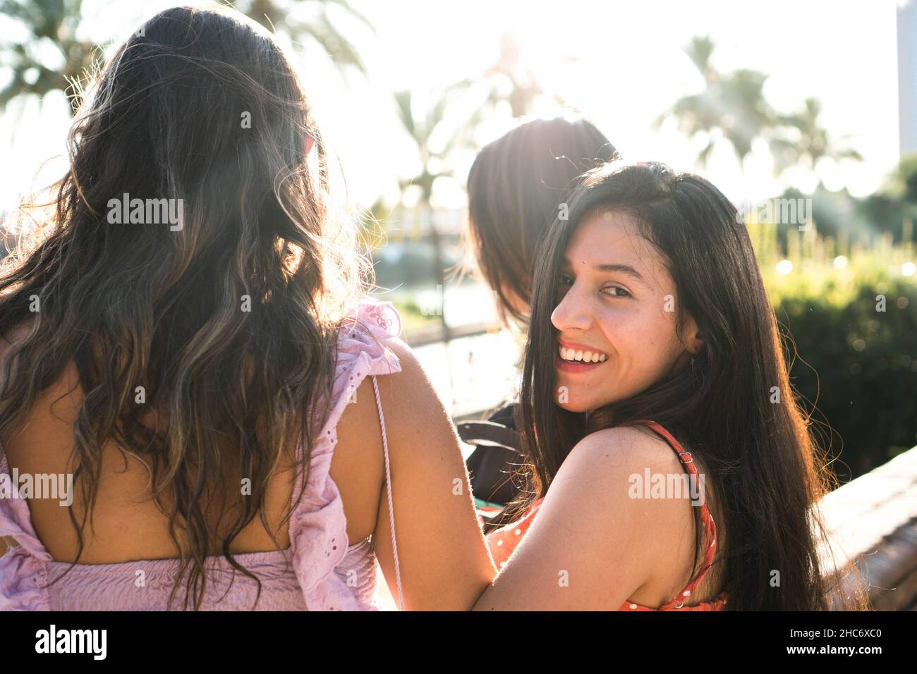 Bella donna latina con i suoi amici che guardano la macchina fotografica. Concetto di amicizia.Ragazze ridendo Foto Stock