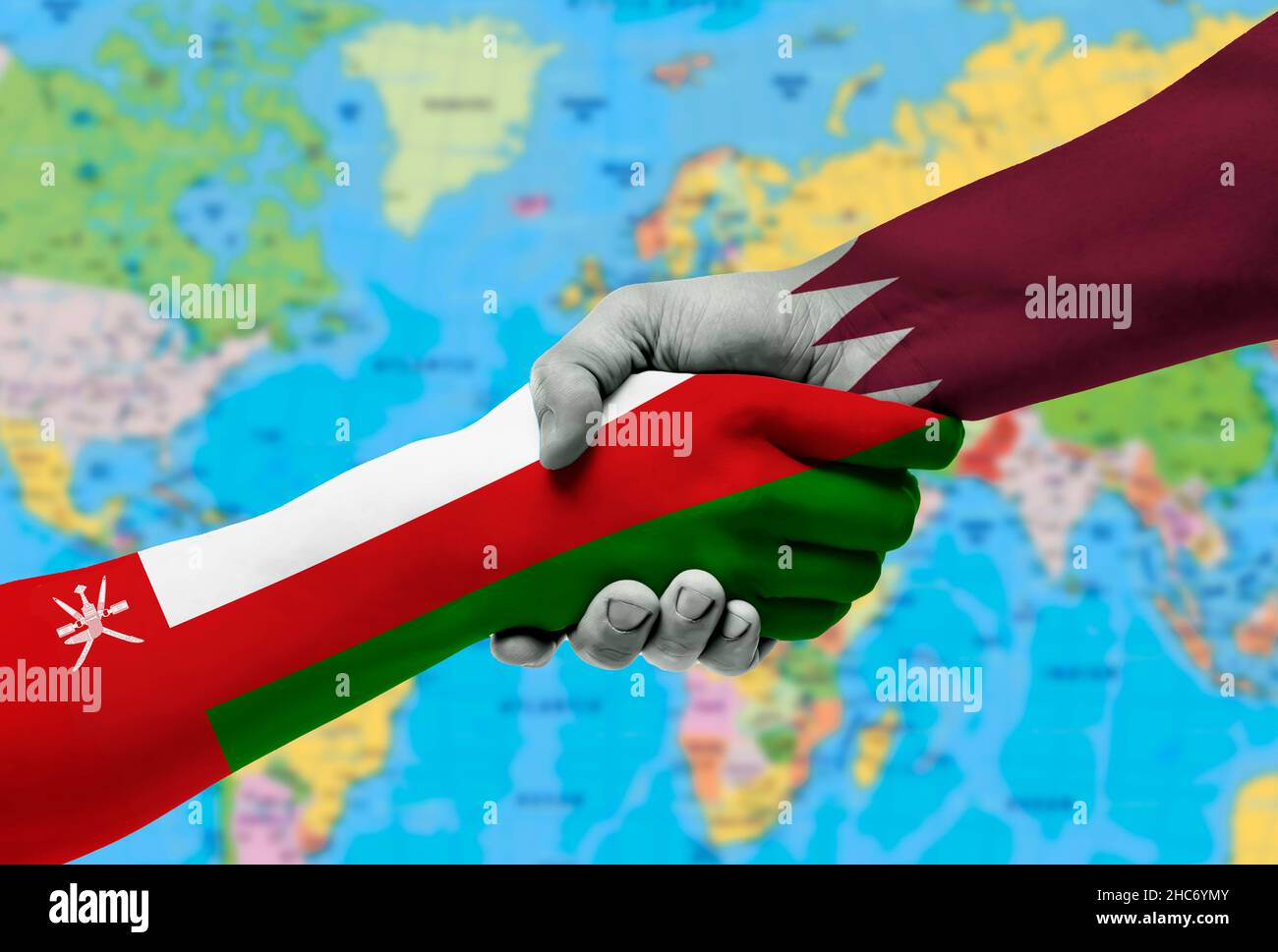 Bandiere Qatar e paesi Oman, cooperazione di handshake, partenariato e amicizia o sport competition.with sfondo della mappa del mondo Foto Stock