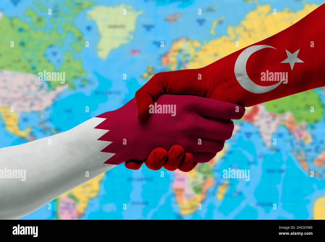 Handshake tra Turchia e Qatar bandiere dipinte su hands.with sfondo della mappa del mondo Foto Stock