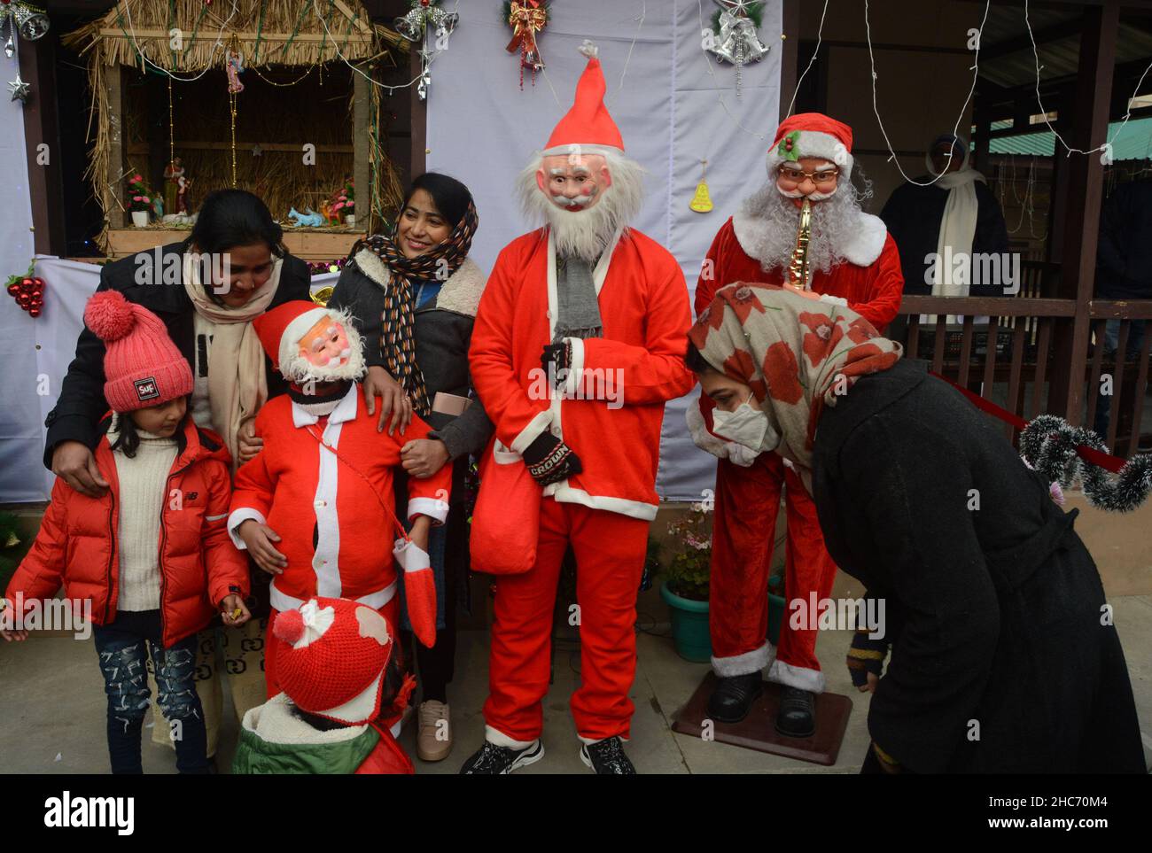 Kashmir, India. 25th Dic 2021. Le giovani ragazze posano per una foto con un uomo vestito come Babbo Natale durante una celebrazione di Natale a Srinagar. Il Natale è un festival annuale che commemora la nascita di Gesù Cristo, osservato principalmente il 25 dicembre come celebrazione religiosa e culturale tra miliardi di persone in tutto il mondo. (Credit Image: © Sajad Hameed/Pacific Press via ZUMA Press Wire) Credit: ZUMA Press, Inc./Alamy Live News Foto Stock