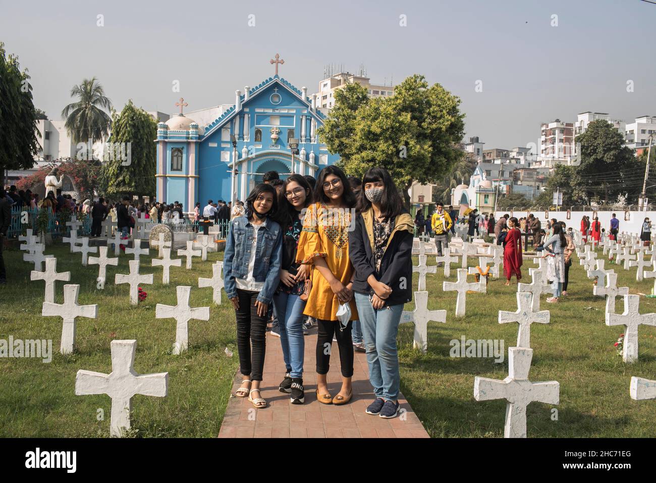 Dhaka, Bangladesh. 25th Dic 2021. I devoti cristiani posano per una foto all'esterno di una Chiesa cattolica del Santo Rosario durante il Natale.il Bangladesh celebra il giorno di Natale, il compleanno di Gesù Cristo, Ma a causa della pandemia del Covid-19 quest'anno, la giornata sarà celebrata su scala limitata, mantenendo le regole di sicurezza sanitaria, compreso il mantenimento delle distanze sociali e l'uso di maschere ovunque. Credit: SOPA Images Limited/Alamy Live News Foto Stock