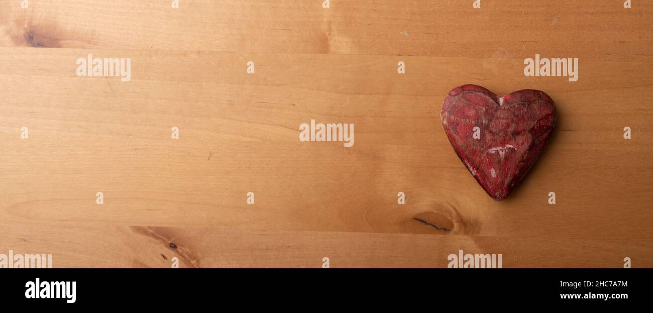 Vista dall'alto di un cuore rosso in pietra su un tavolo di legno - amore e affetto Foto Stock