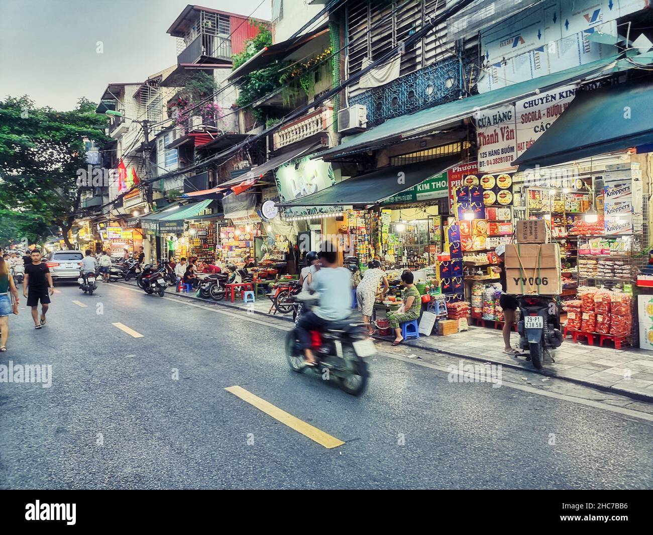 Strada trafficata con persone che guidano motociclette ad Hanoi, Vietnam Foto Stock