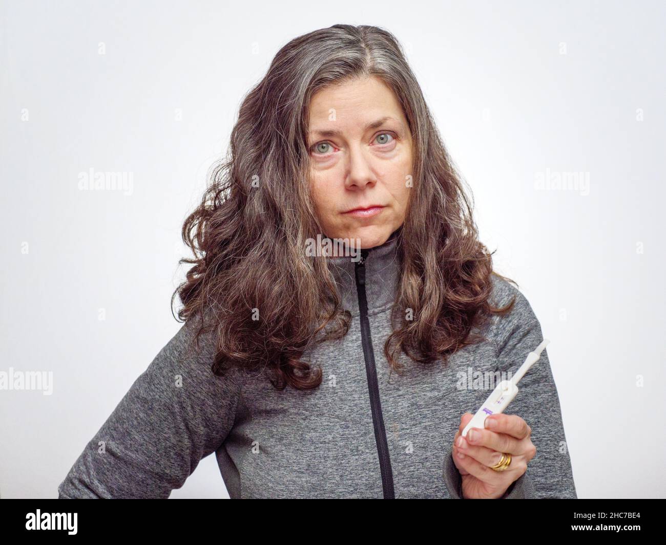 Donna con tampone per test antigene COVID-19 a casa. Foto Stock