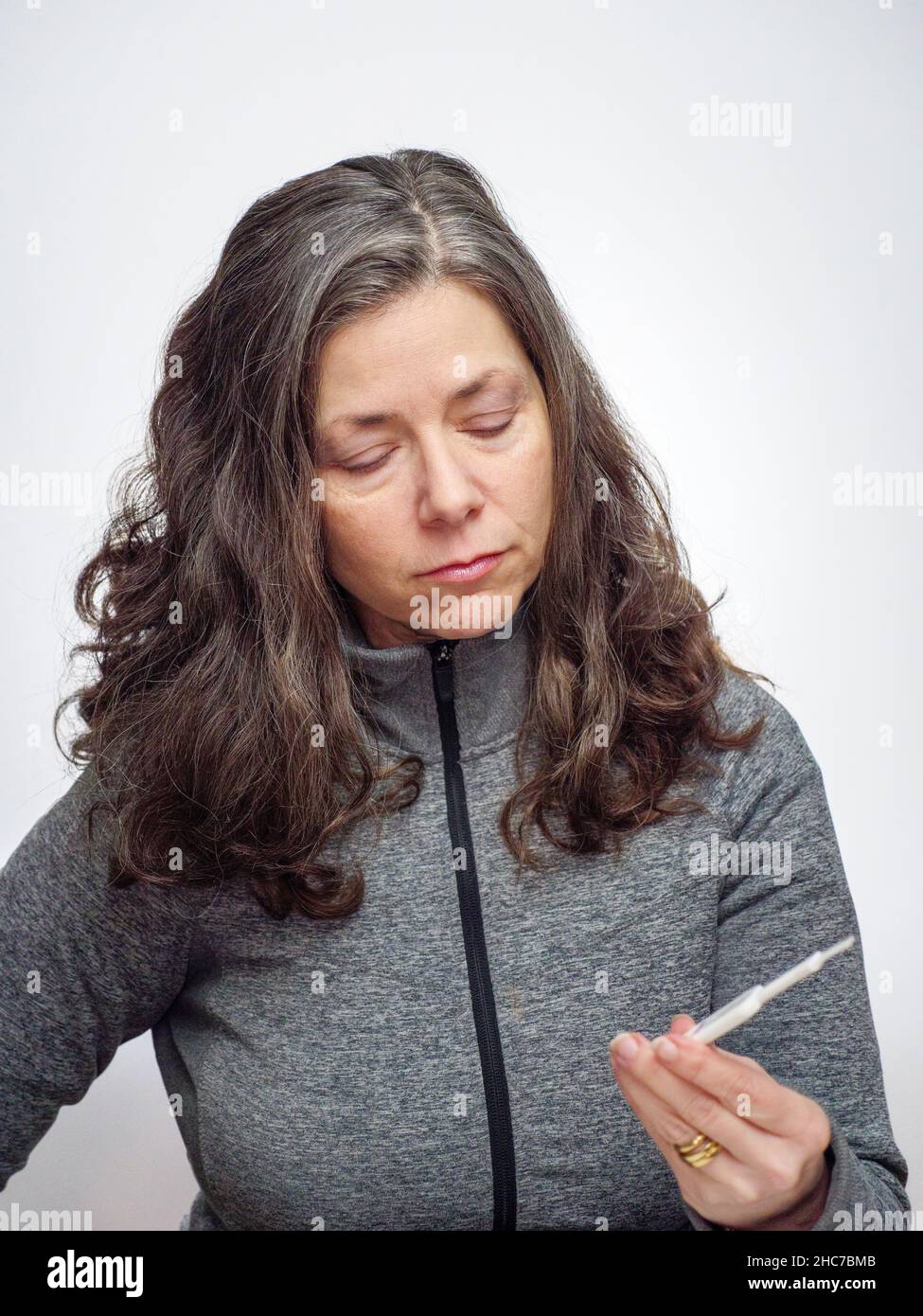 Donna che guarda a casa COVID-19 antigene tampone test. Foto Stock