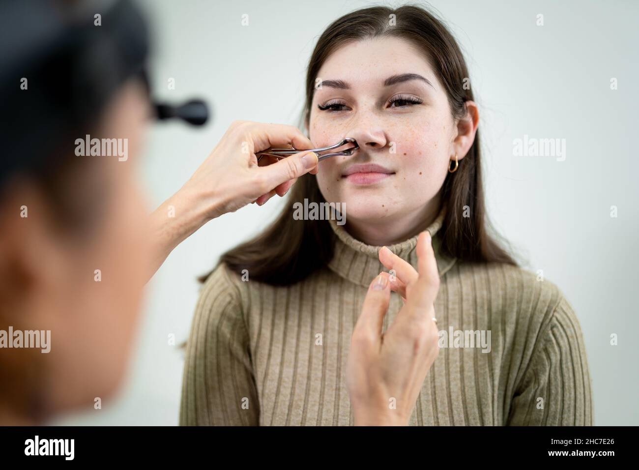 Dottore professionale di otorhinolaringologist che fa esame del naso con otoscopio in ospedale moderno. Congestione nasale, sinusite, allergia concetto Foto Stock