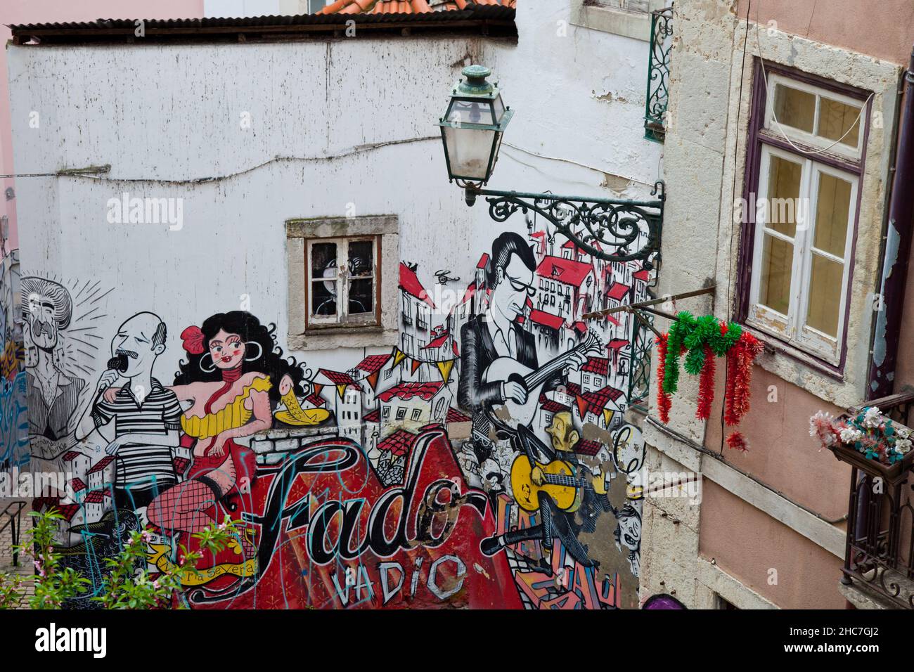 Grafiti di una band che suona su una chitarra e canta e una donna che balla a Lisbona, Portogallo Foto Stock