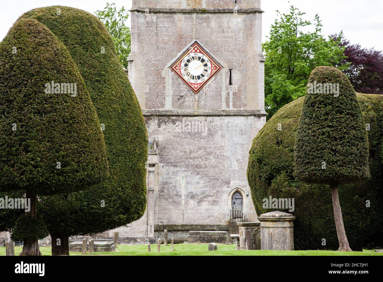 Vista della Chiesa Orologio e alberi di tasso Painswick Cotswold's. Foto Stock