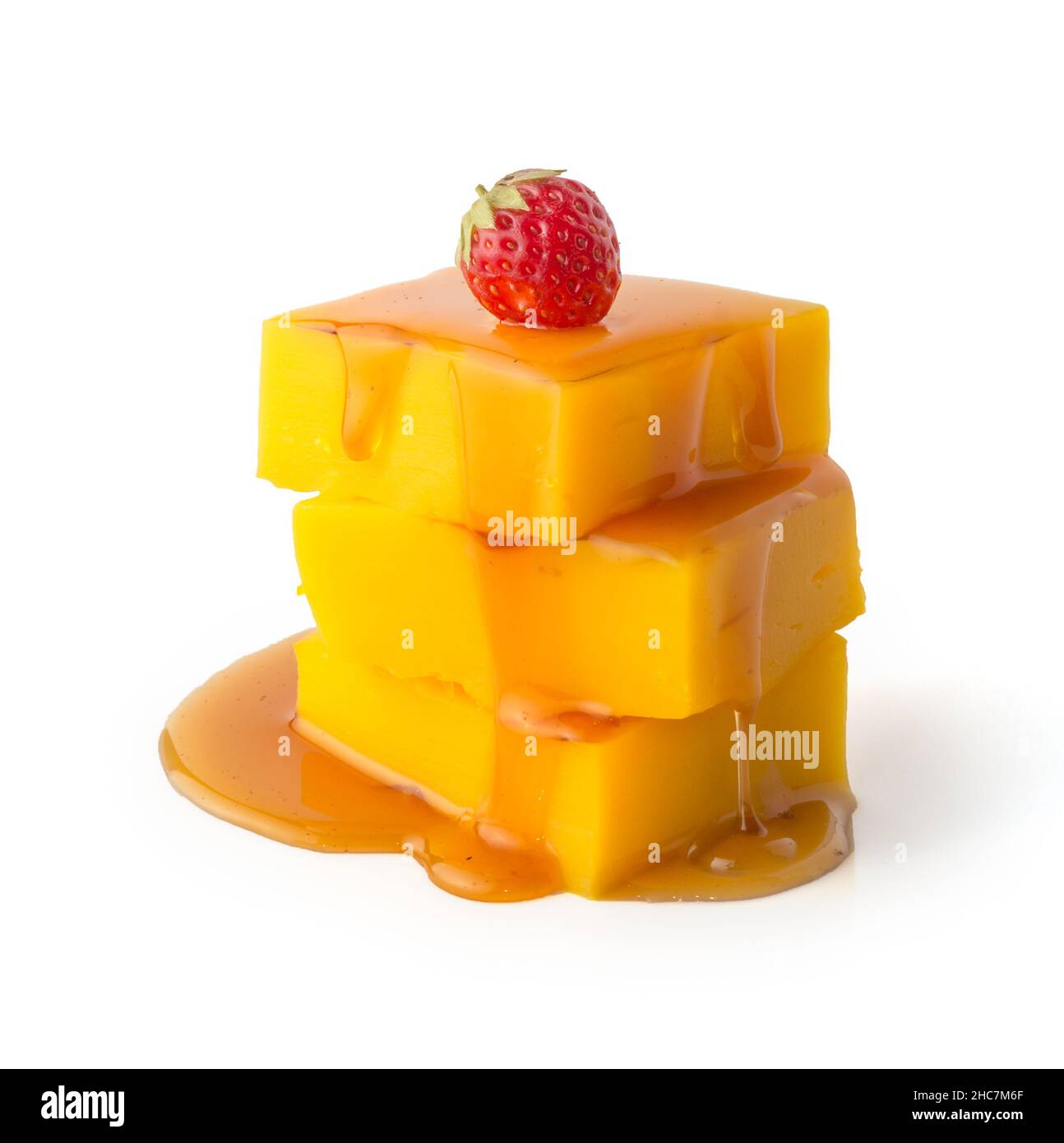 pezzetti di crema pasticcera con salsa di caramello versata, fragola rossa matura sulla parte superiore isolata su sfondo bianco Foto Stock