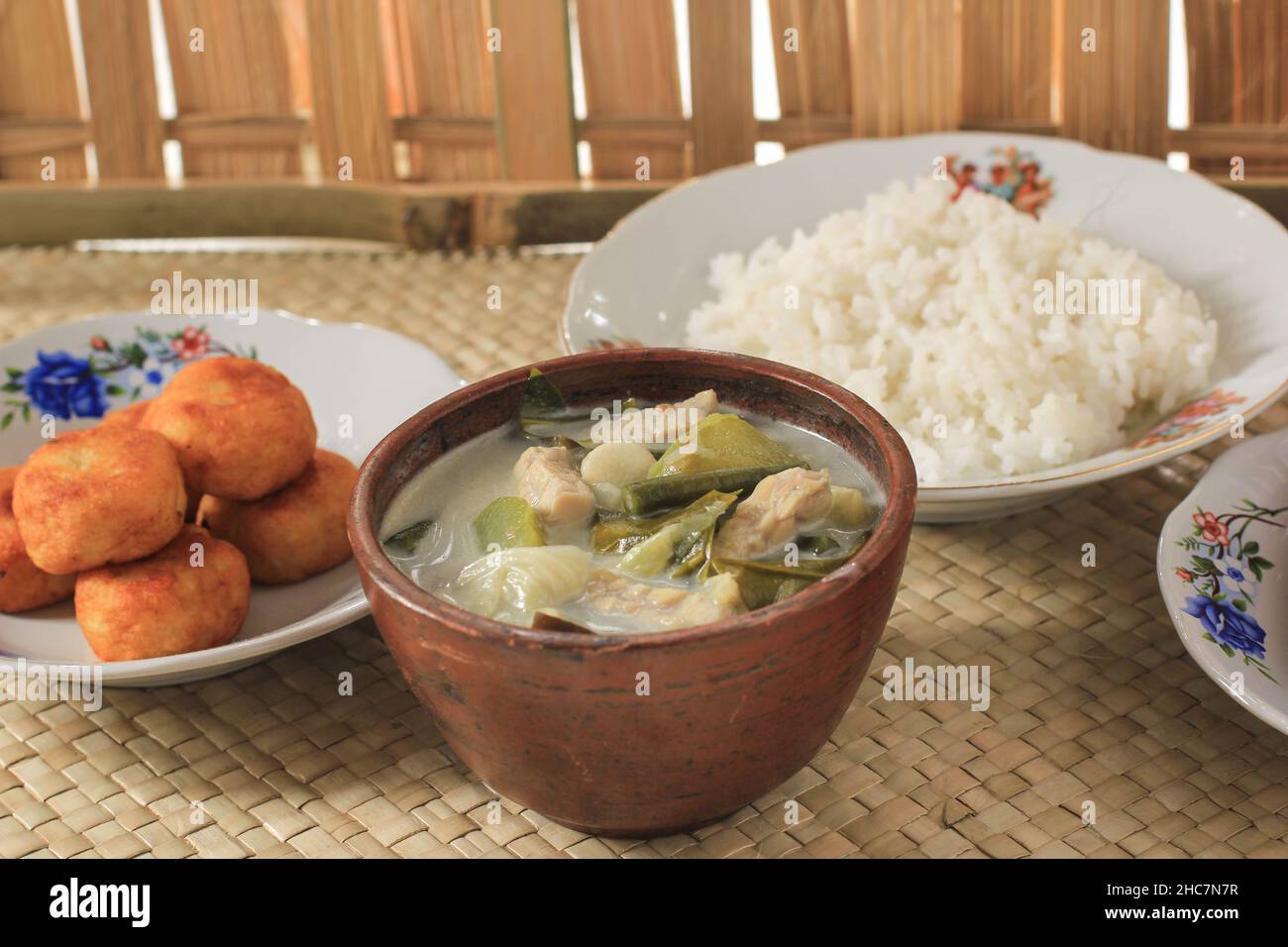 Lodeh Sayur o verdure con zuppa di latte di cocco. Tradizionale cucina Indonesiana da Java in tradizionale ciotola servita su Bamboo Table. Selettivo Foto Stock