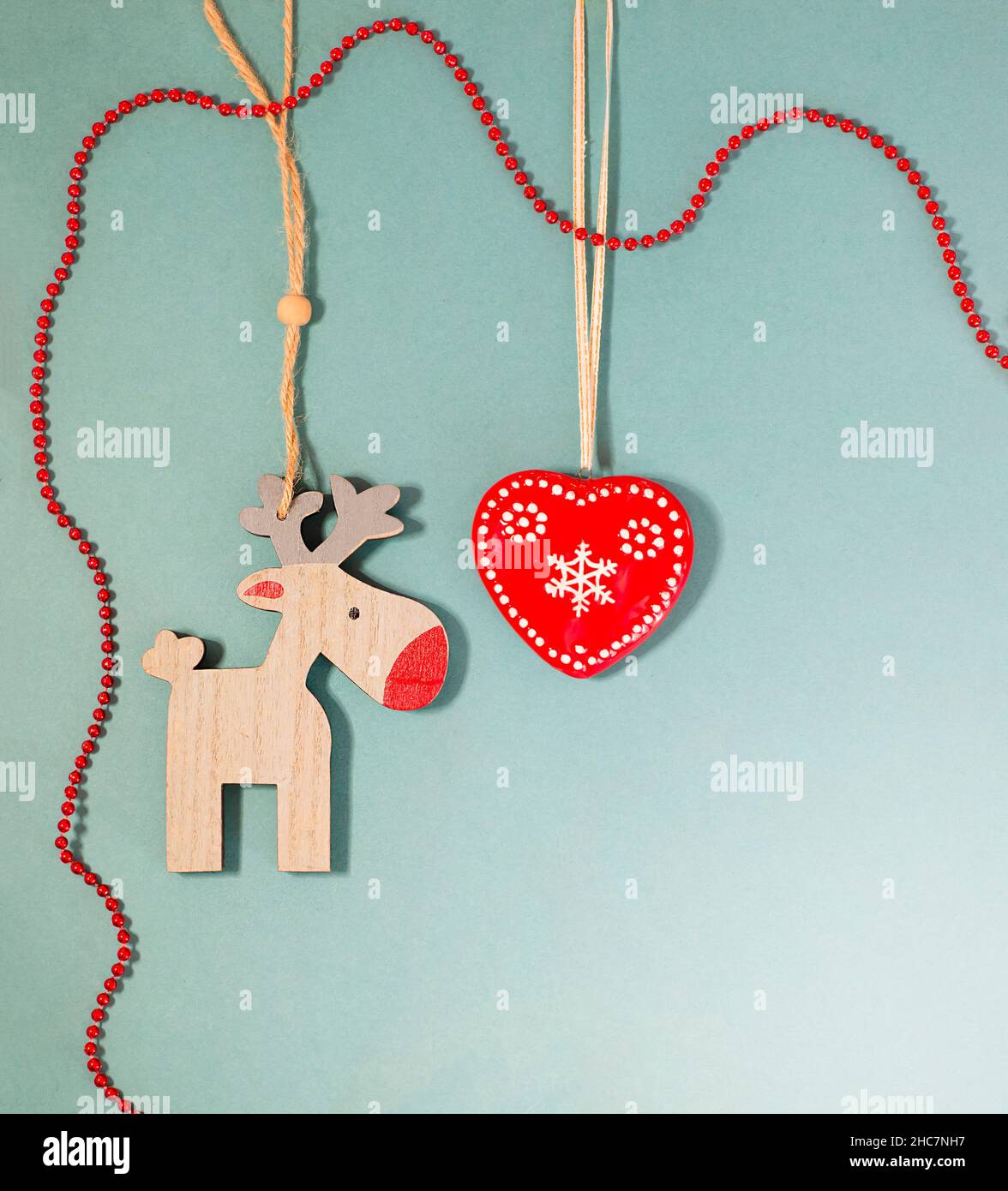 Design retrò. Cervo. Cuore con un fiocco di neve e perle rosse. Spazio di copia per il testo. Foto Stock