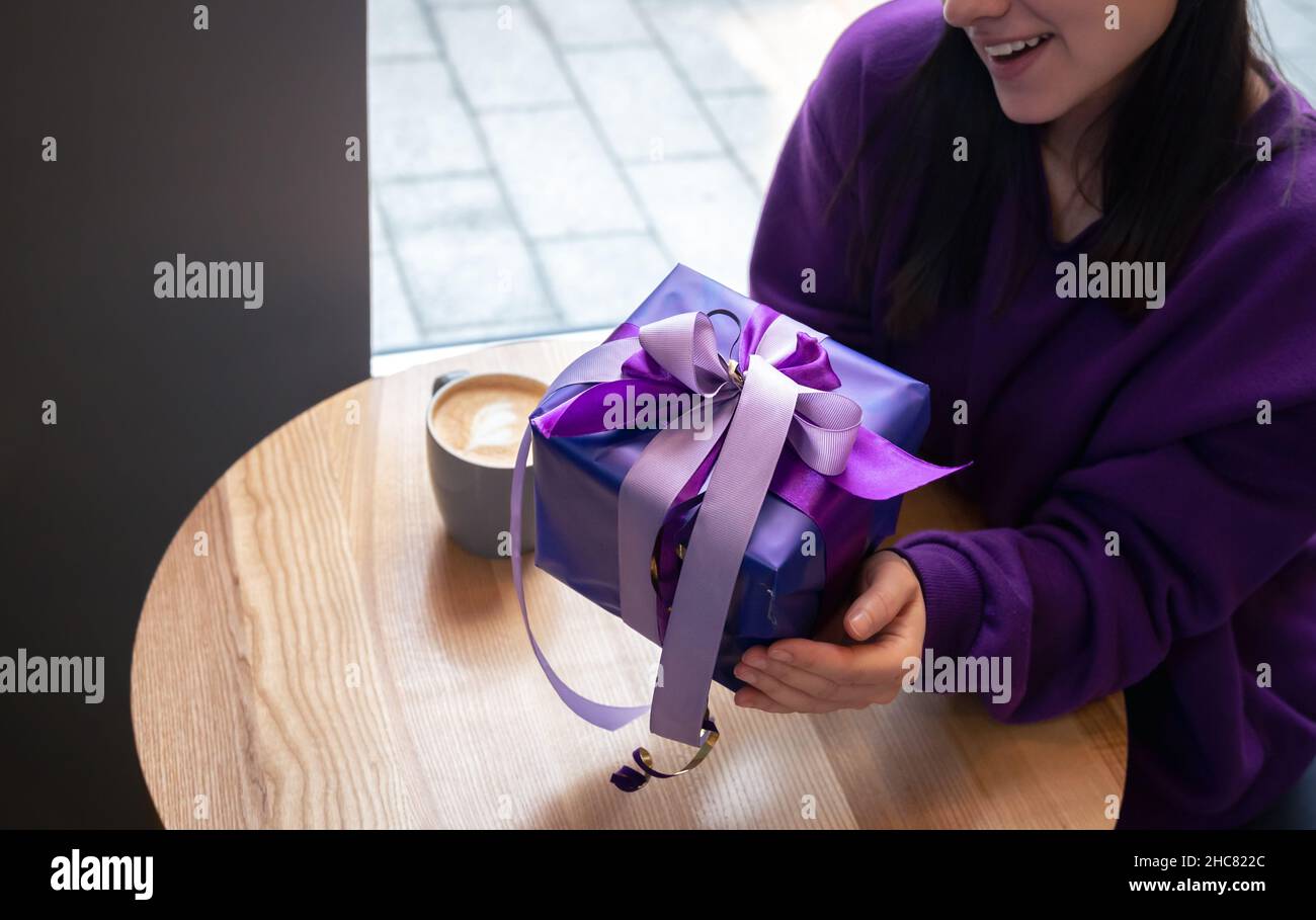 Giovane donna sorridente in un maglione viola e jeans isolato su bianco  Foto stock - Alamy