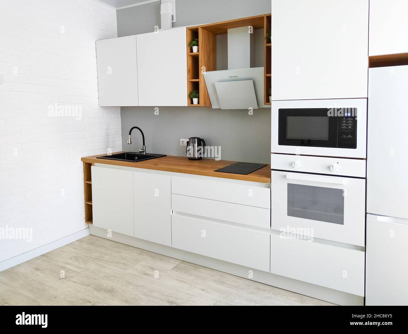 Cucina bianca interno scandinavo con cappa da cucina su piano di lavoro in  legno Foto stock - Alamy