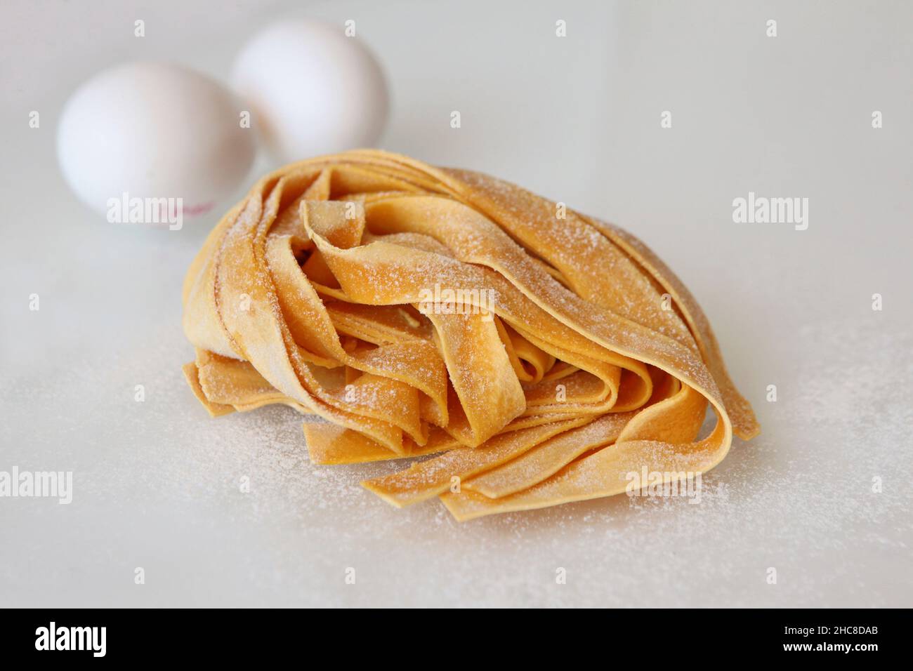 Linguine uovo pasta su sfondo bianco Foto Stock