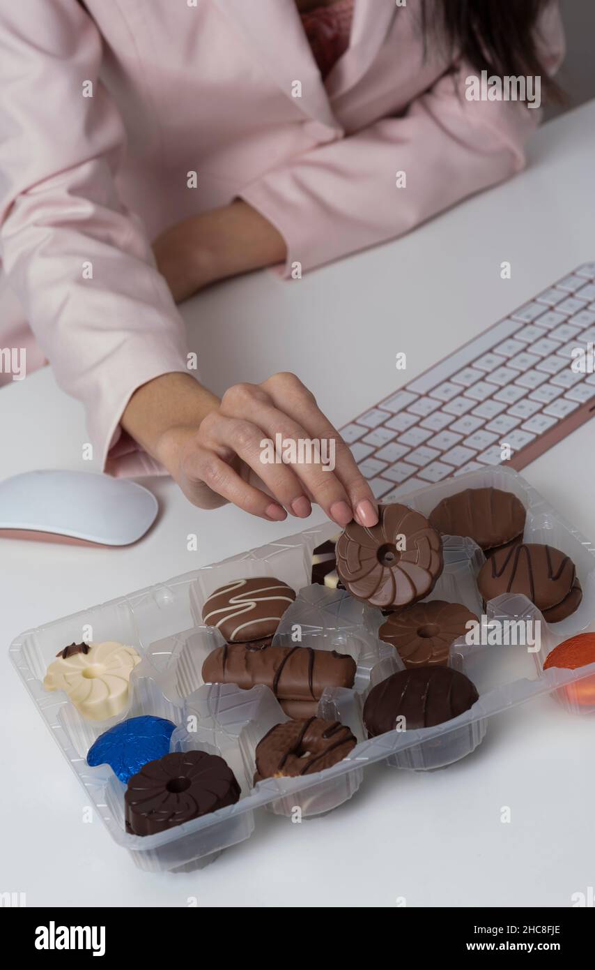 Biscotti al cioccolato in scatola di plastica da un keboaard, una tentazione per un utente di computer Foto Stock