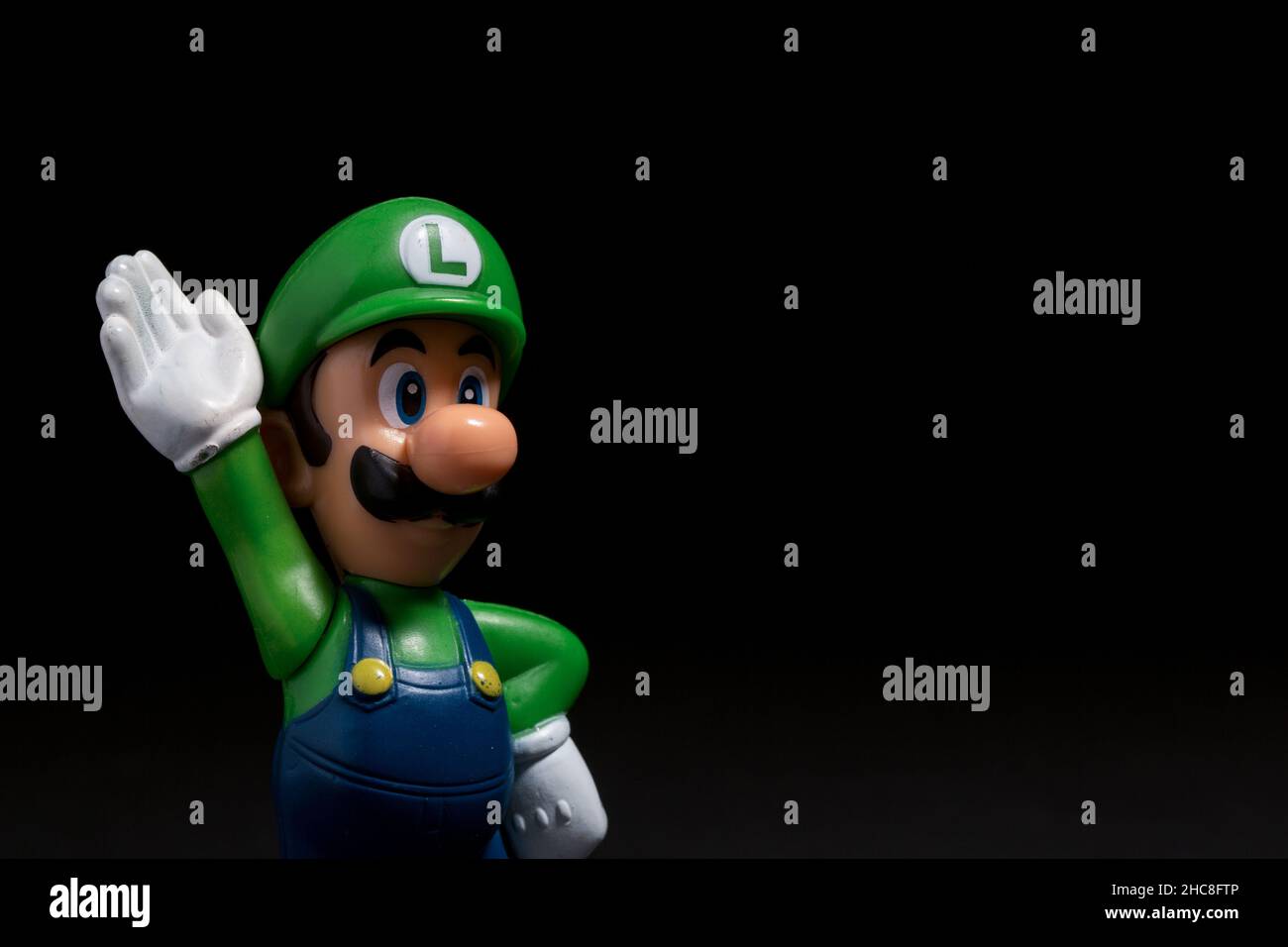 Mosca, Russia - 27 dicembre 2021: Figura plastica di Luigi dal videogioco Nintendo isolato su sfondo nero. Foto Stock