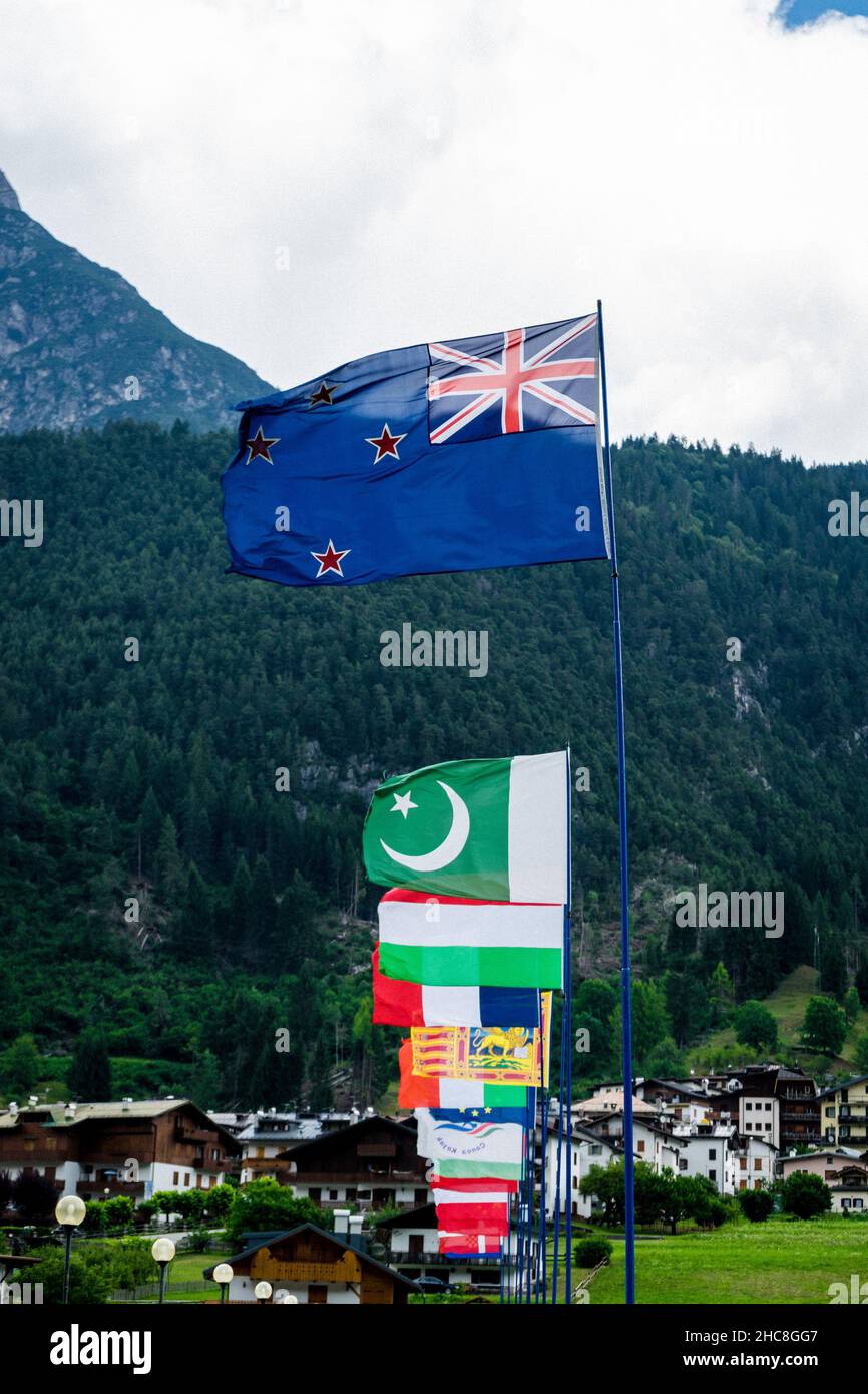 Diverse bandiere di fronte alle montagne. Bandiera dell'Australia davanti. Poi bandiera pakistana, bandiera italiana e altre bandiere nelle Dolomiti, Italia. Foto Stock