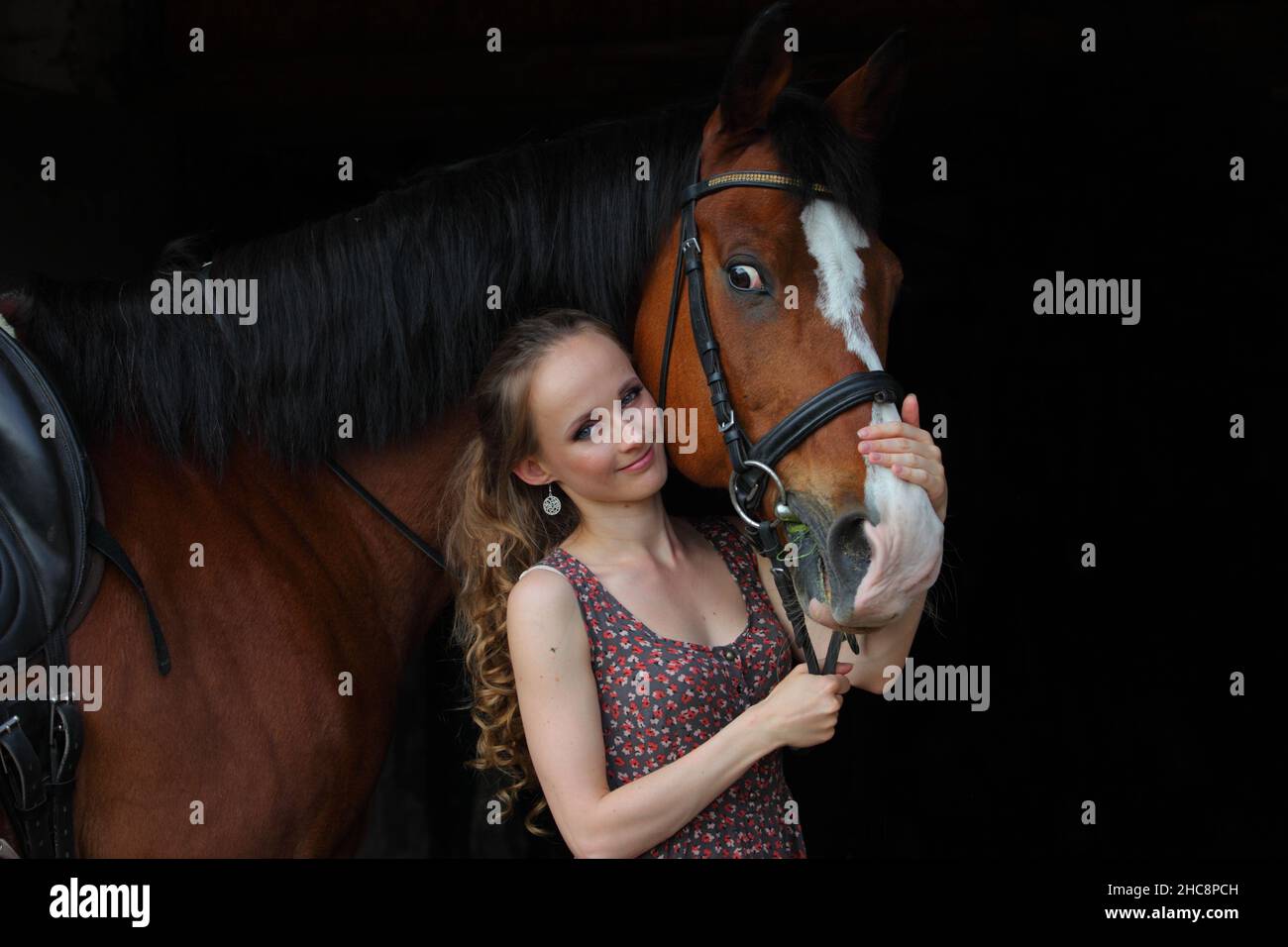 Bella ragazza di campagna in posa con cavallo sella nel ranch Foto Stock