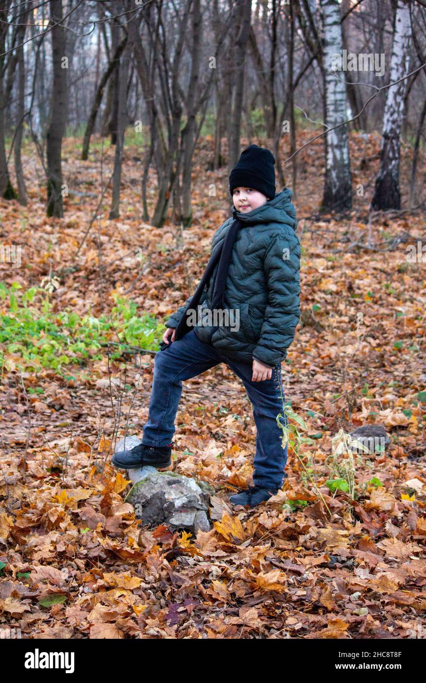 Il ragazzo è in piedi nel parco autunnale. Foto Stock