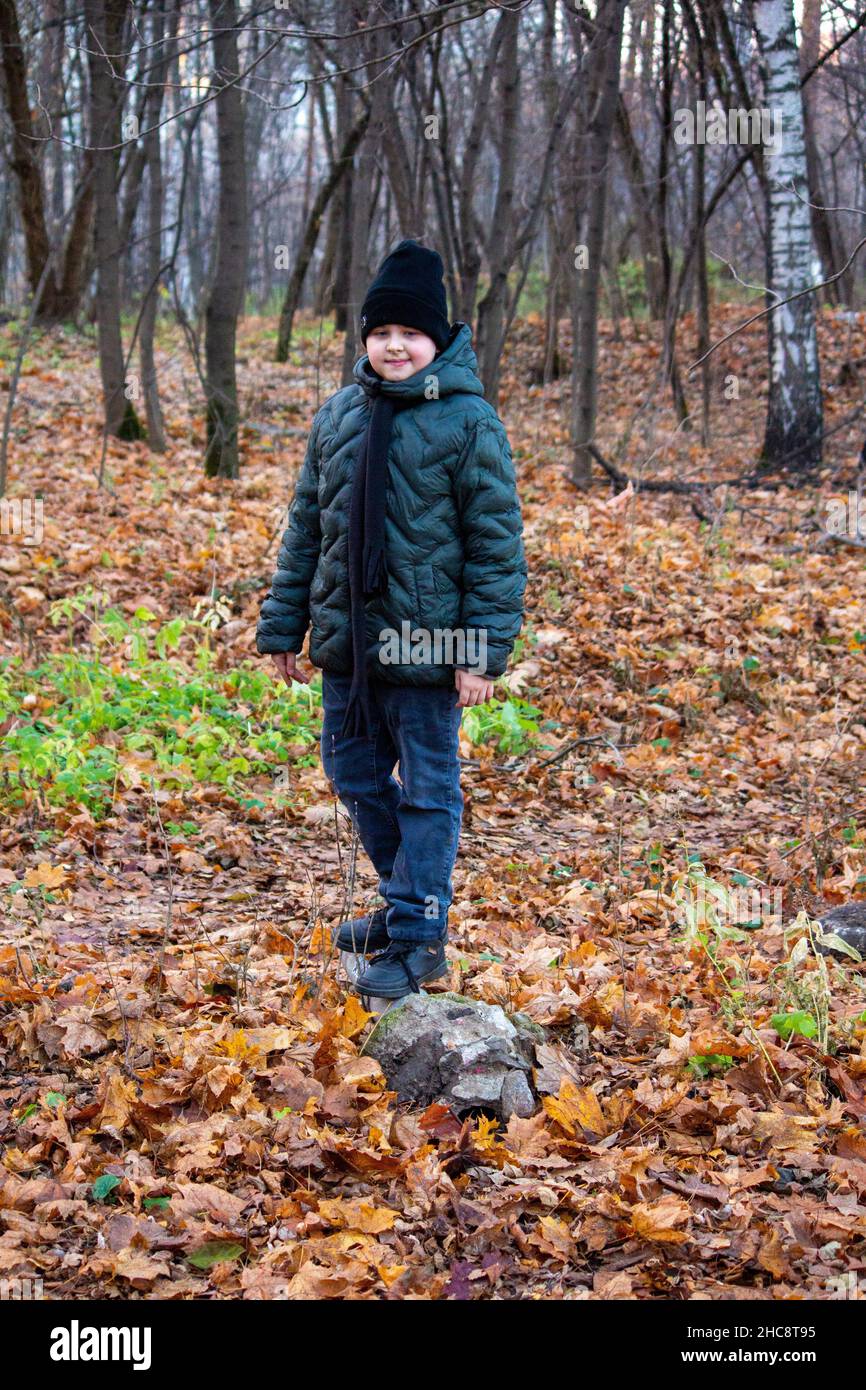 Il ragazzo è in piedi nel parco autunnale. Foto Stock