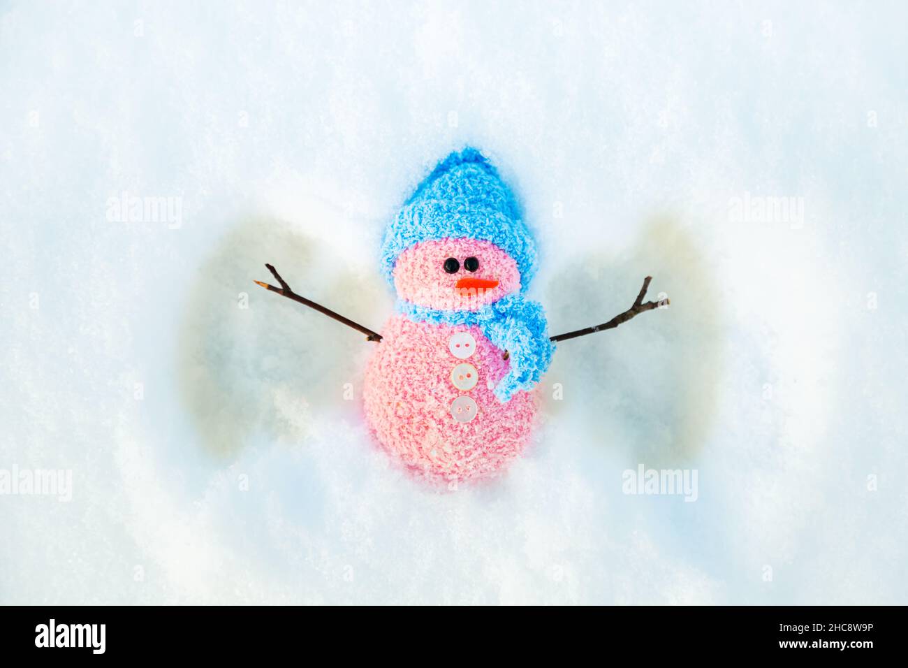 Carino pupazzo di neve fa un angelo di neve. Sfondo invernale con spazio copia. Foto Stock