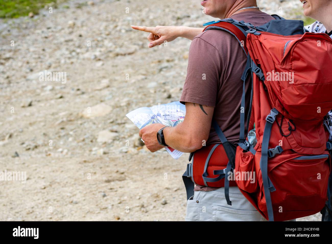 Primo piano di un turista cercando di trovare il posto che vuole con l'aiuto di un locale e una mappa Foto Stock