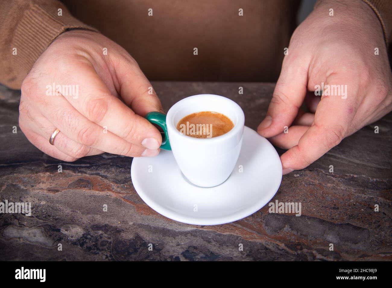 Mani maschili con una tazza di espresso in primo piano. Foto Stock