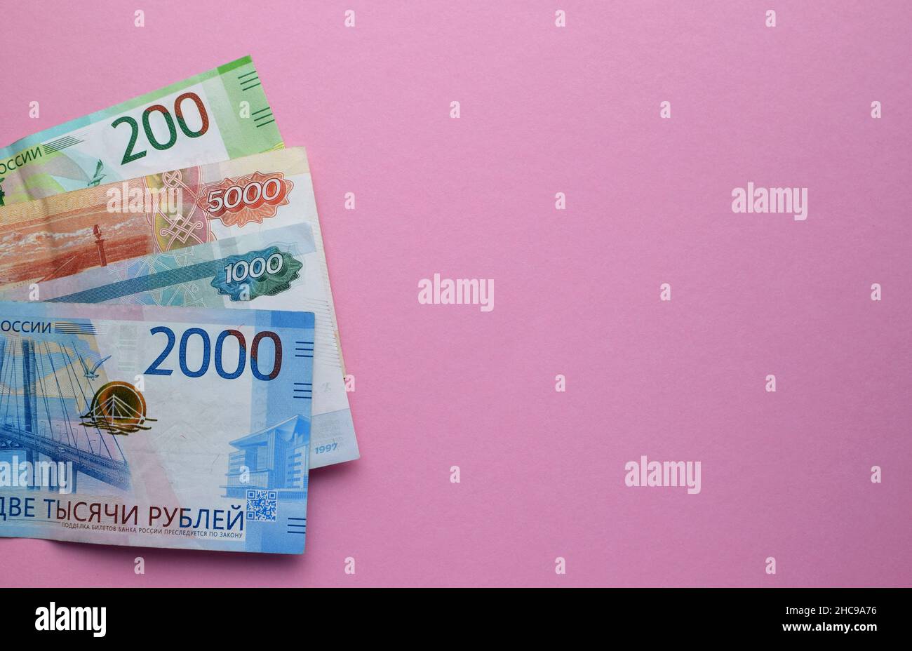 Rubli russi su sfondo rosa. Migliaia di banconote e monete varie. Spazio di copia. Foto Stock