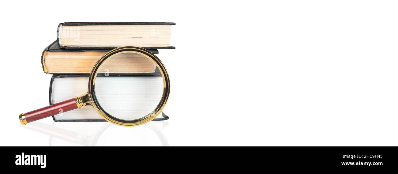 Lente di ingrandimento sopra il libro di carta aperto. Concetto di conoscenza, ricerca e studio. Banner con spazio per la copia del testo. Foto Stock