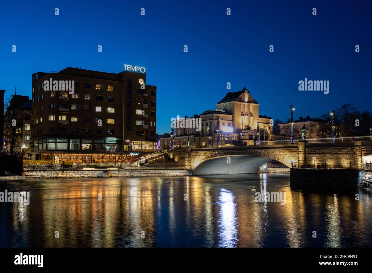 Rapide di Tammerkoski, Hämeensilta illuminate e edifici circostanti dopo il tramonto a Tampere, Finlandia Foto Stock