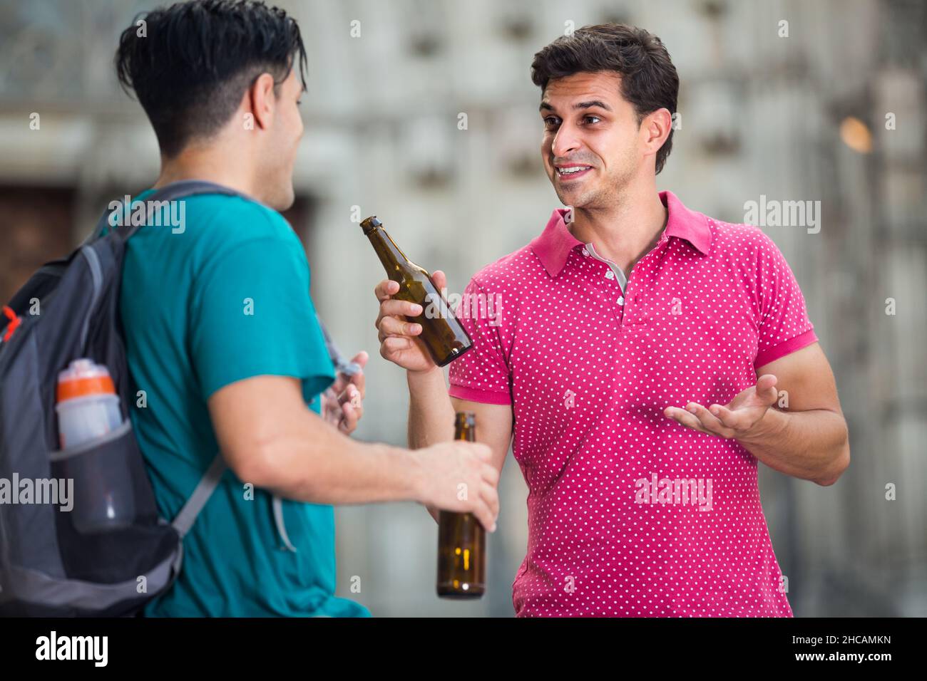 Gli uomini adulti bevono birra e parlano Foto Stock