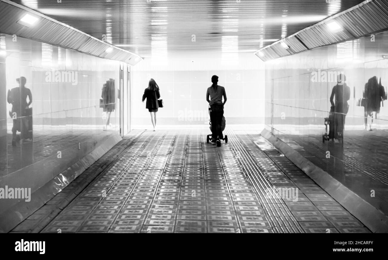 Silhouette di persone, ragazze e donne che camminano attraverso il passaggio verso la luce esterna. Concetto: Vedere luce, libro o copertina album Foto Stock