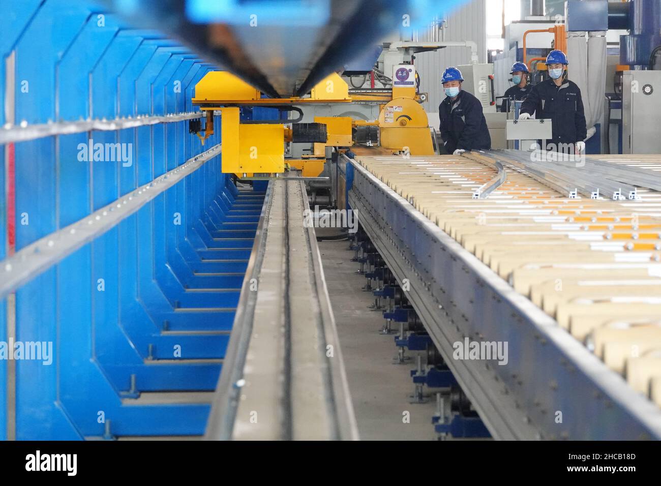 YANTAI, CINA - 27 DICEMBRE 2021 - Un lavoratore produce materiali leggeri presso il Centro di innovazione Automotive Lightweight di Yantai, Shandong Provin Foto Stock