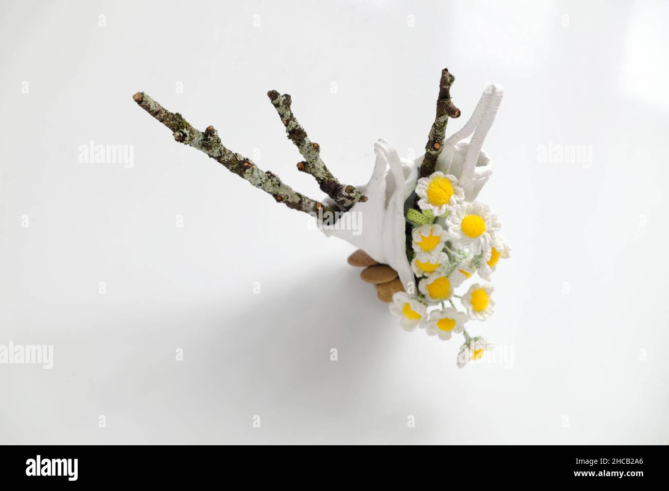 Vaso Daisy per arredamento casa, vaso fiore diy da riciclare maschera viso con cemento bianco, crochet piccolo fiore bianco con pistil giallo e ramo secco di albero Foto Stock