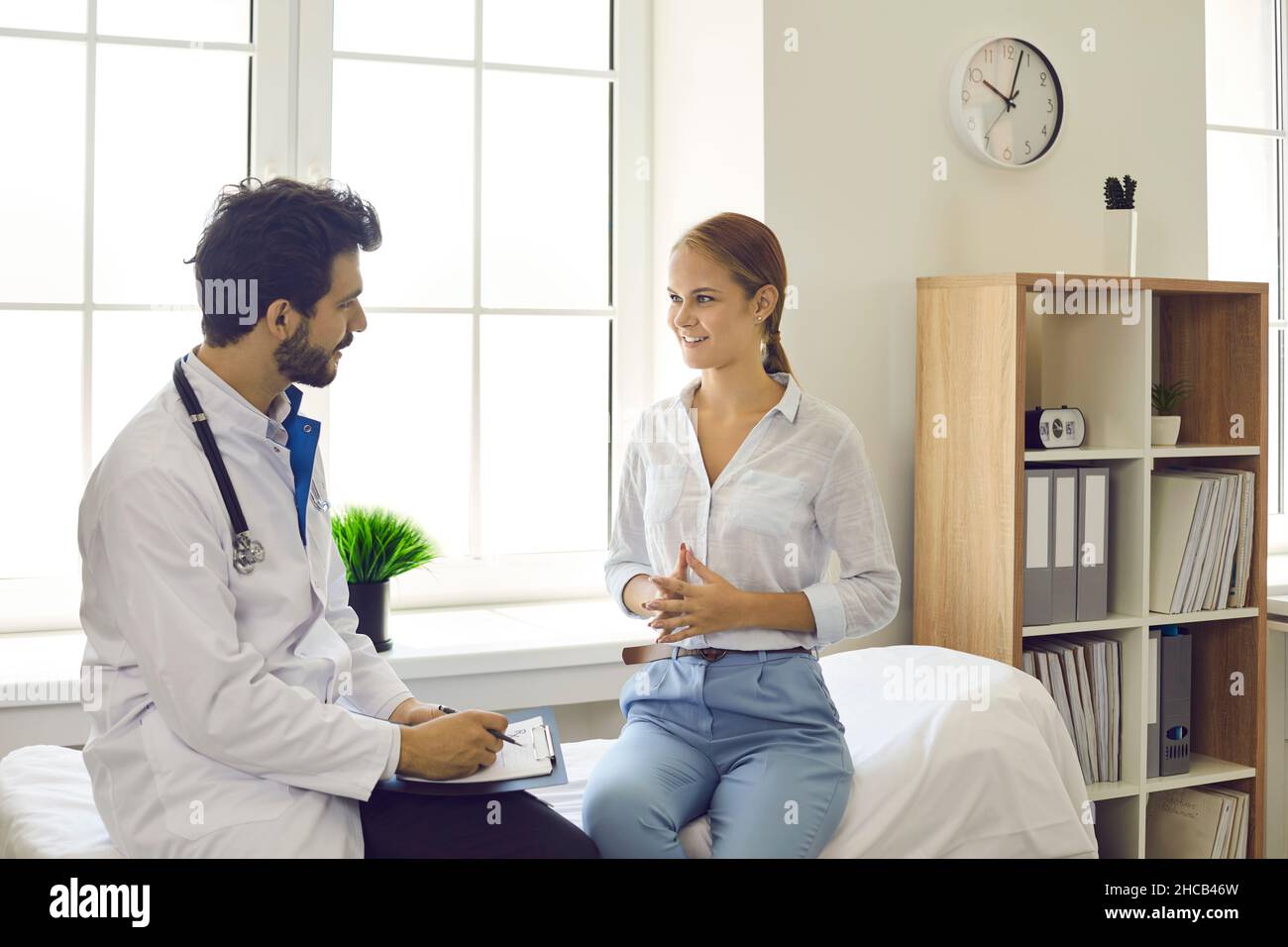 GP maschio consultare paziente donna in ospedale privato Foto Stock